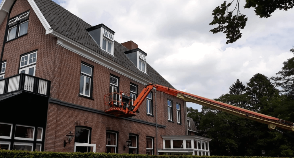 Procesfoto schilderwerk buitenkant huis met hoogwerker